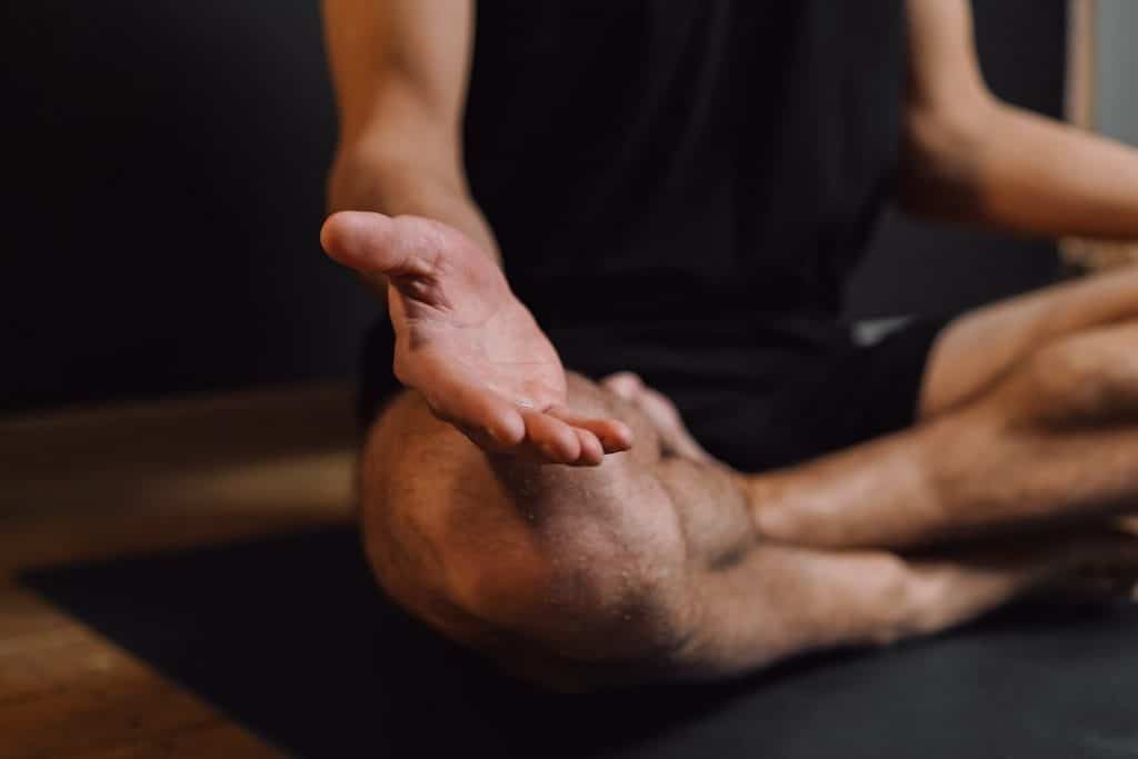 Practicing breath awareness and conscious breathing, photo of hands and knees of man meditating